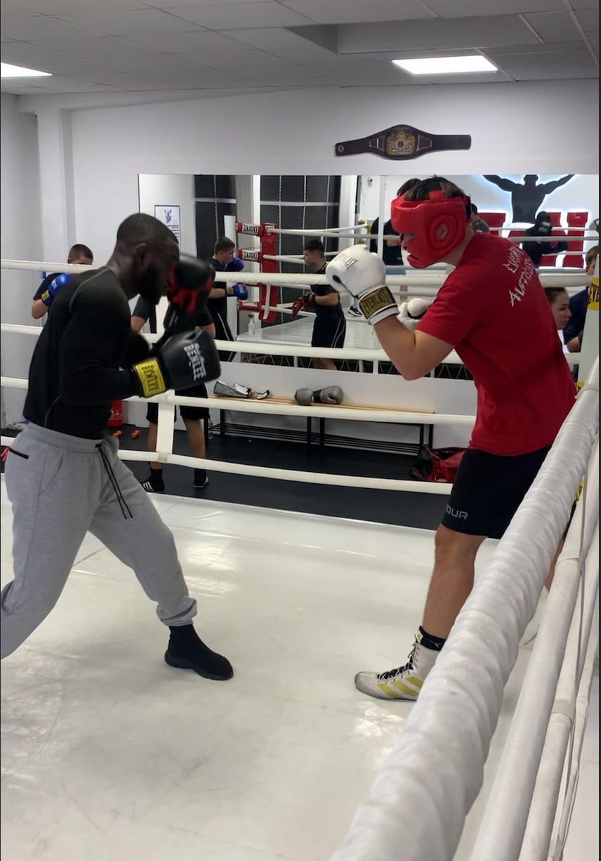 Two boxers sparring in a ring during training